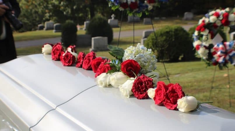 White Coffin with Red and White Roses at a Funeral